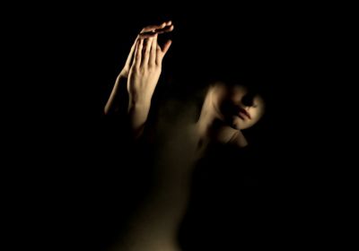 Imagem destaque do post de uma mulher na escuridão para representar o lado sombra dos arquétipos.